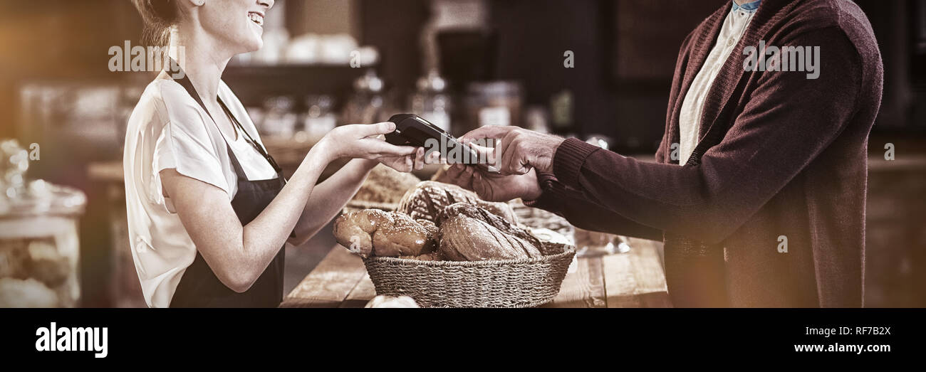 Lächelnde Kunden zahlen mit Kreditkarte Stockfoto