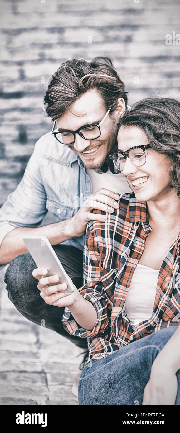 Junges Paar mit Handy Stockfoto