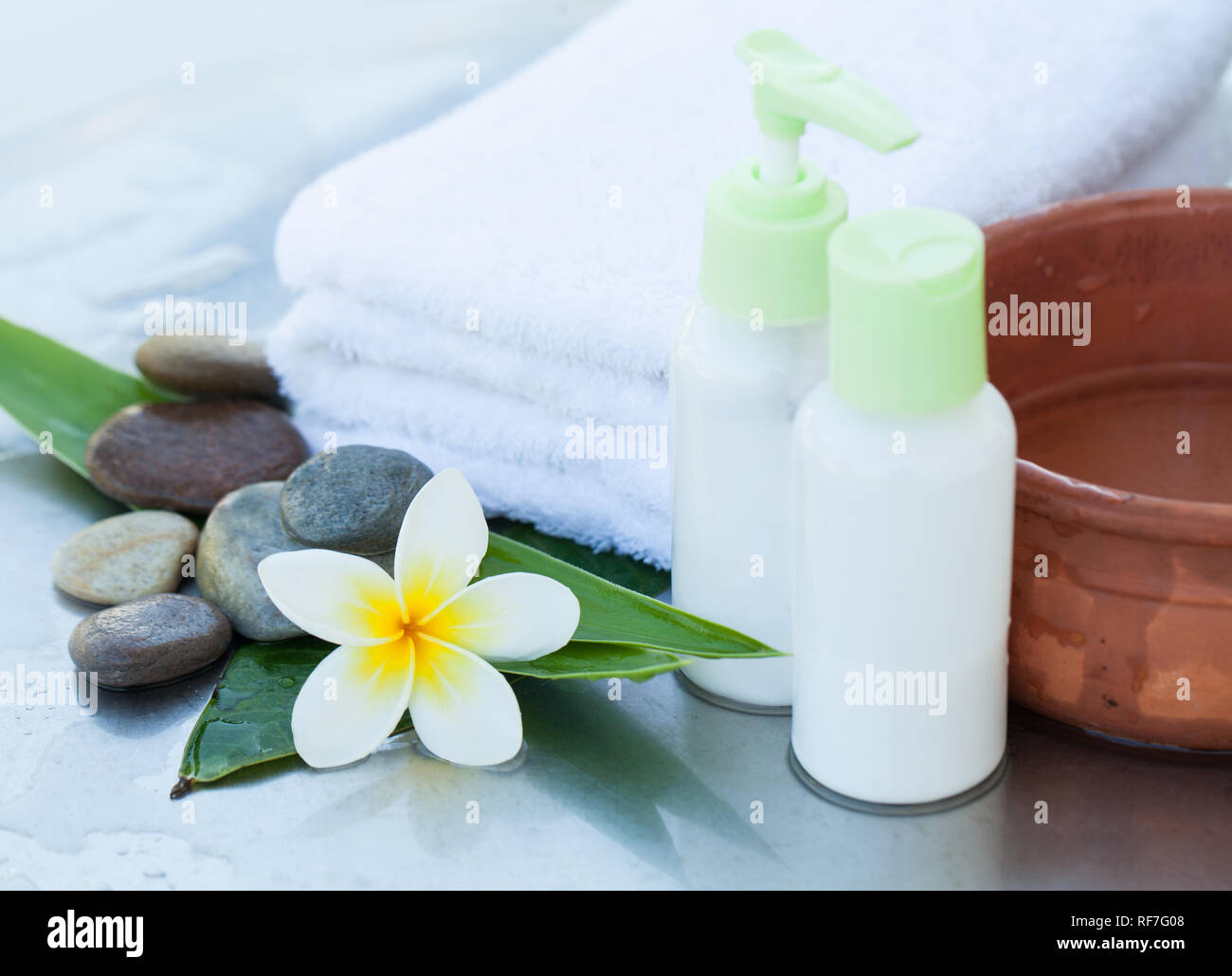 Spa, Wellness oder Hintergrund mit weißer Bettwäsche, tropische Blätter, Blumen, Körper und Gesicht pflege Werkzeuge und Zubehör auf weißem Hintergrund Stockfoto