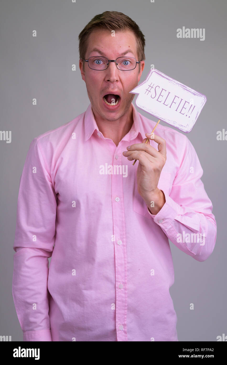 Portrait von überrascht junge Unternehmer mit selfie Papier anmelden Stockfoto