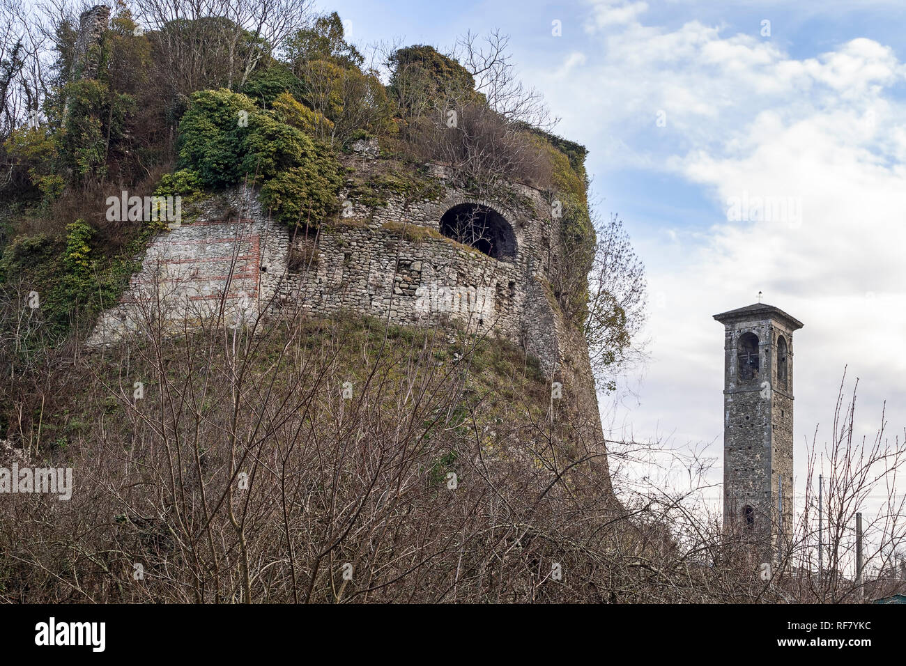 Ein Teil der alten Malnido Burgruinen in Villafranca in Lunigiana, und Saint Nicolo Kirchturm. Beseitigung von Vegetation in Arbeit Januar 2019. Stockfoto