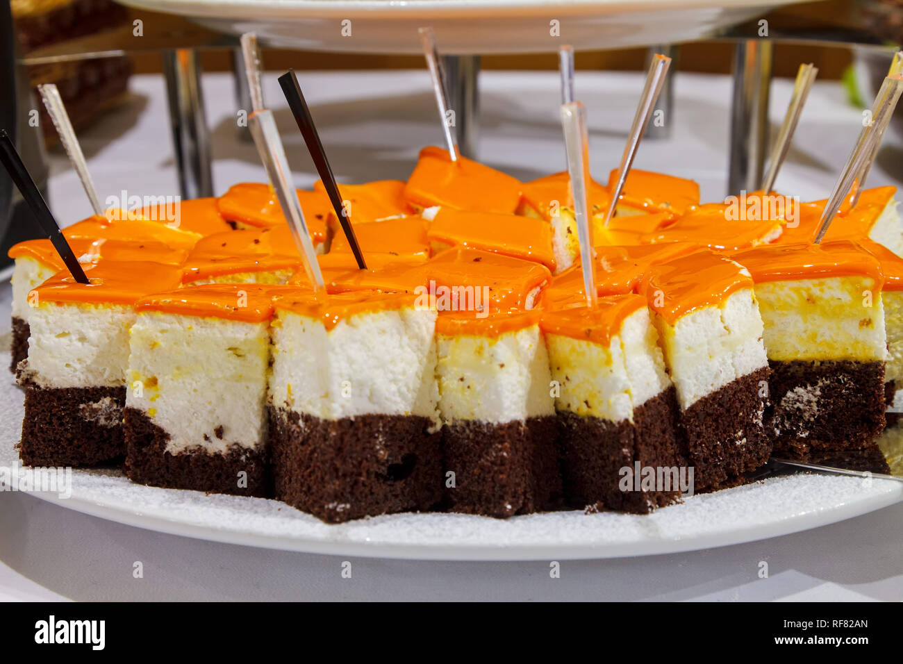 Schokolade Biskuit mit Frischkäse souffle gekrönt mit glänzend orange Glasur. Von der Seite. Close-up Stockfoto