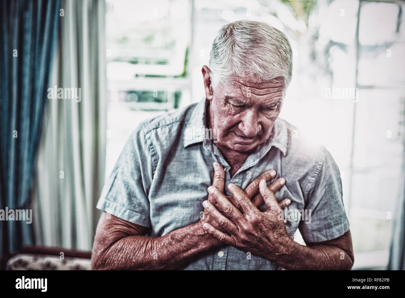 Ältere Mann leidet unter Schmerzen in der Brust Stockfoto