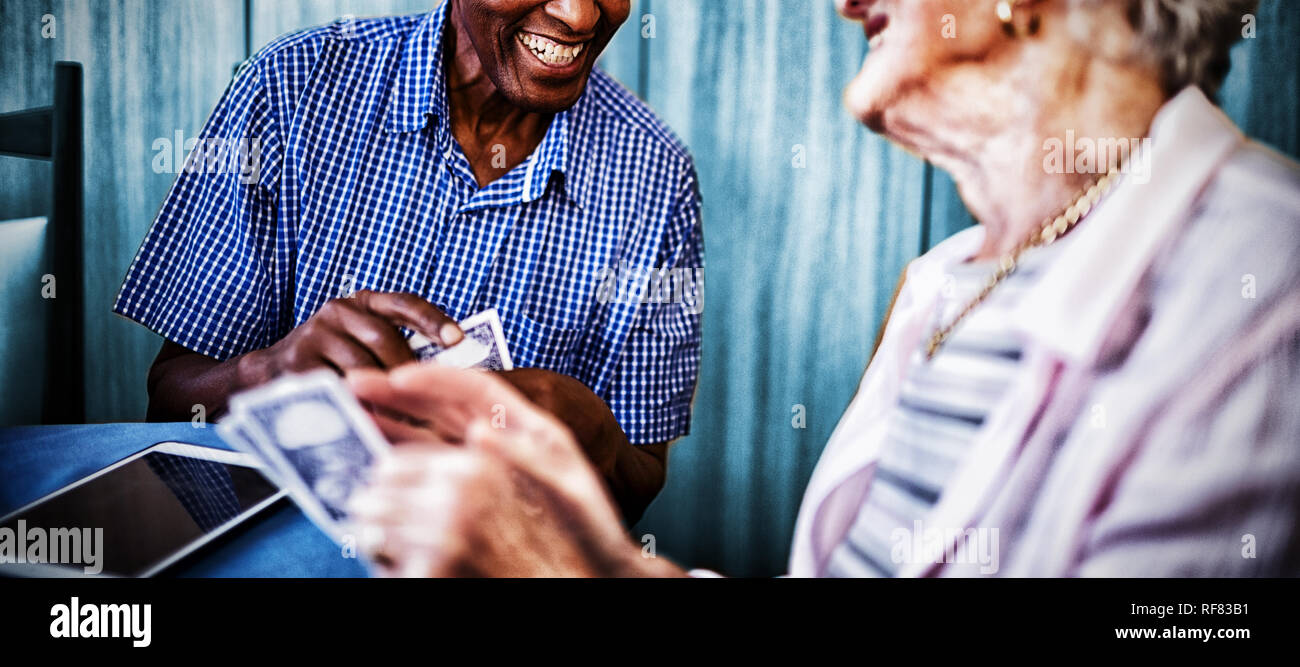 Lächelnde ältere männliche und weibliche Freunde Karten Stockfoto