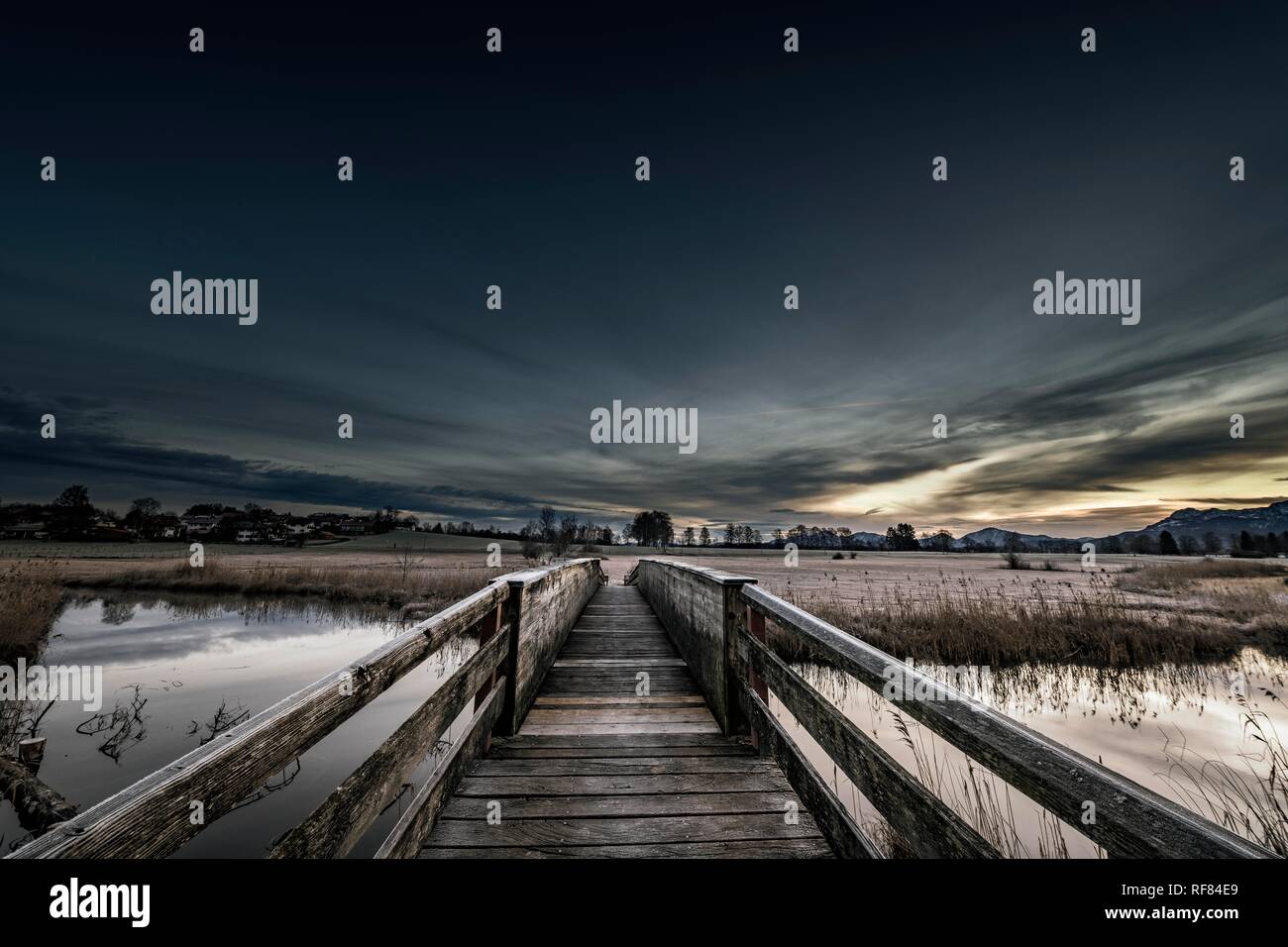 Holzsteg über die Ach mit Reflexion und dramatische Himmel, Uffing, Staffelsee, Oberbayern, Deutschland Stockfoto