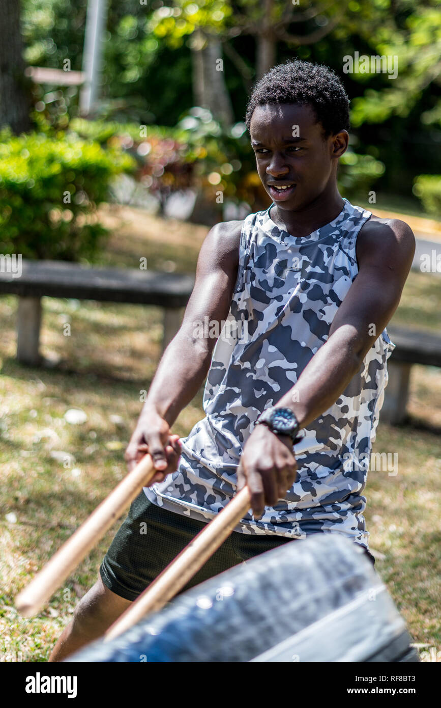 Ein afrikanischer Junge spielt eine japanische taiko Drum eines alten Reifen und Klebeband gemacht Stockfoto
