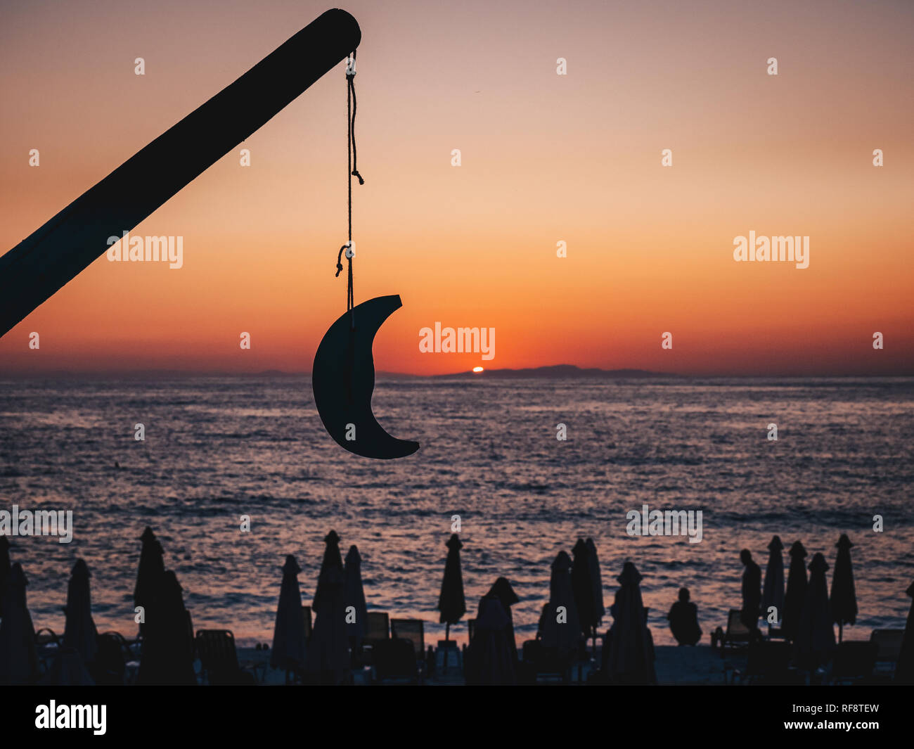 Schönen Sonnenaufgang in Thassos, Griechenland mit der Sonne aus dem Meer, Touristen am Strand den Sonnenaufgang und ein Modell Mond. Fokus auf dem Mond. Stockfoto
