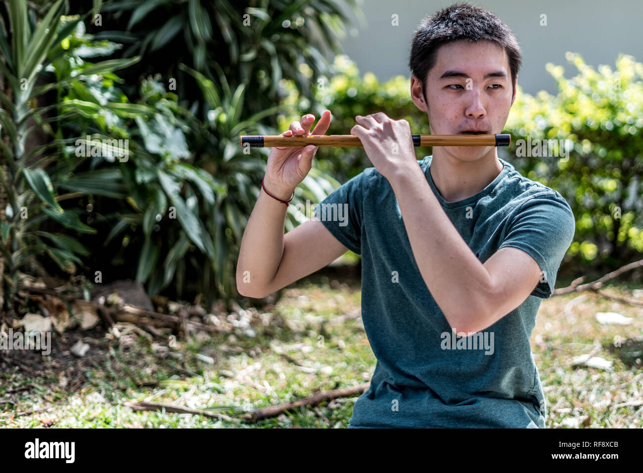 Ein japanischer Mann spielt und Alt Flöte in einer wunderschönen natürlichen Umgebung. Stockfoto