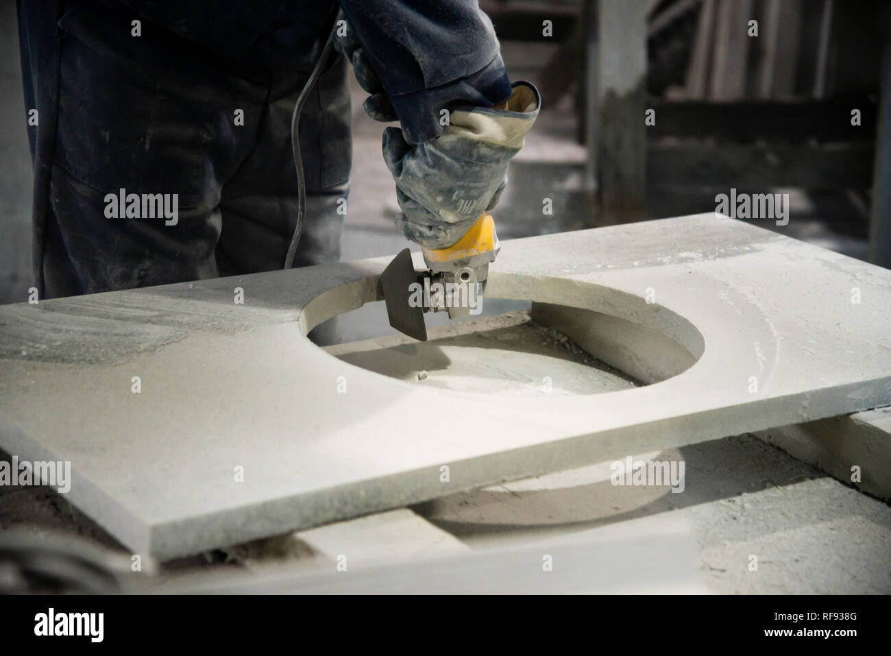 Man polieren Marmor Stein Tabelle von kleinen Winkelschleifer. Steinwerkstatt Stockfoto