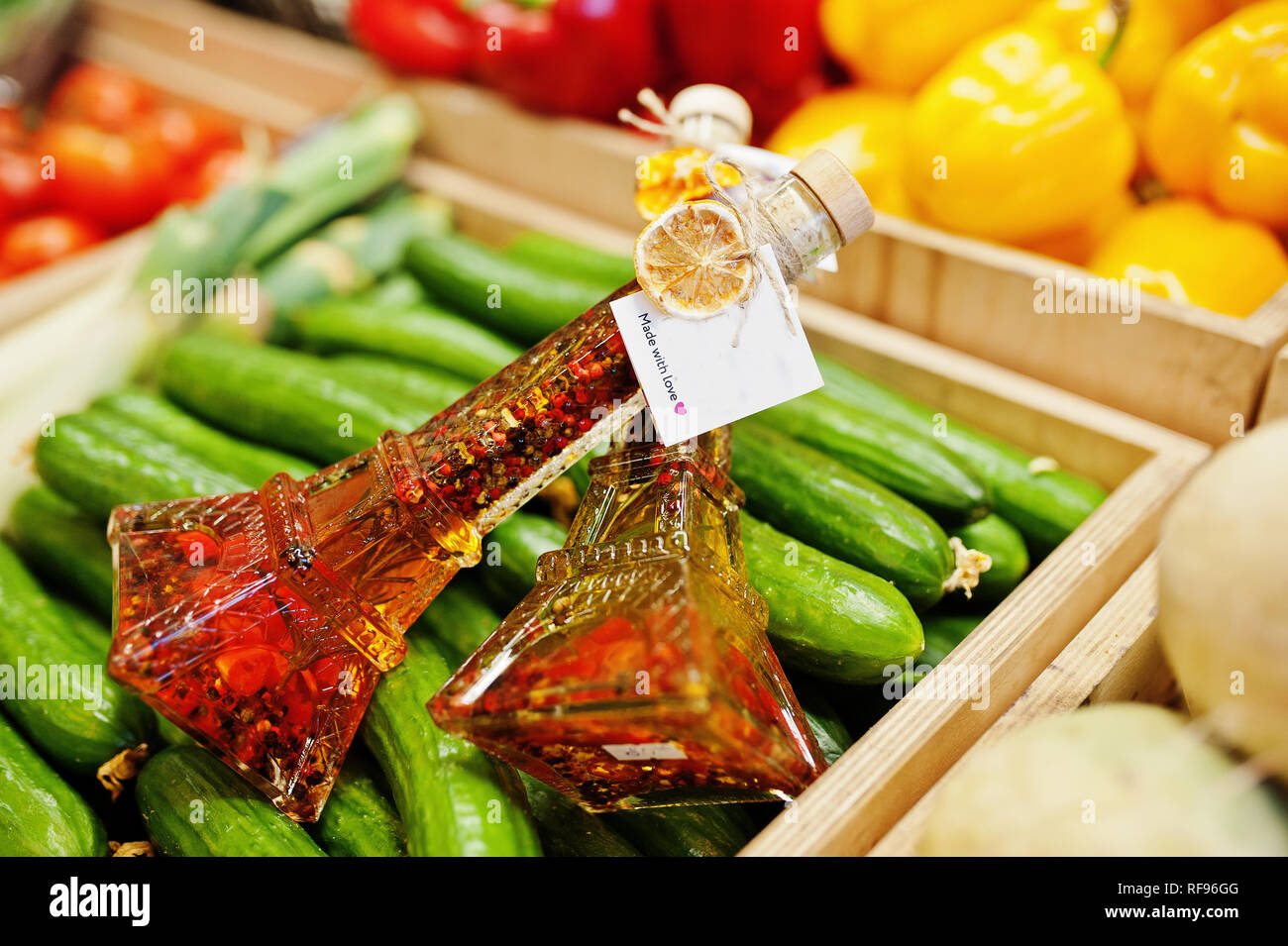Zwei natives Olivenöl Gläser mit Gewürzen auf der Flasche wie Eifel Turm auf dem Regal mit Gurken im Supermarkt oder ein Lebensmittelgeschäft. Mit Liebe gemacht. Stockfoto