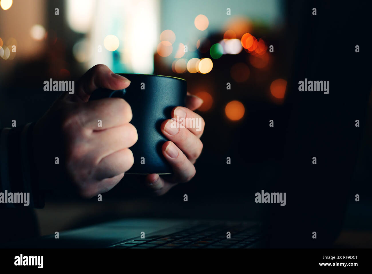 Frau mit Kaffee Tasse mit Laptop in der Nacht, in der Nähe der Hände Stockfoto