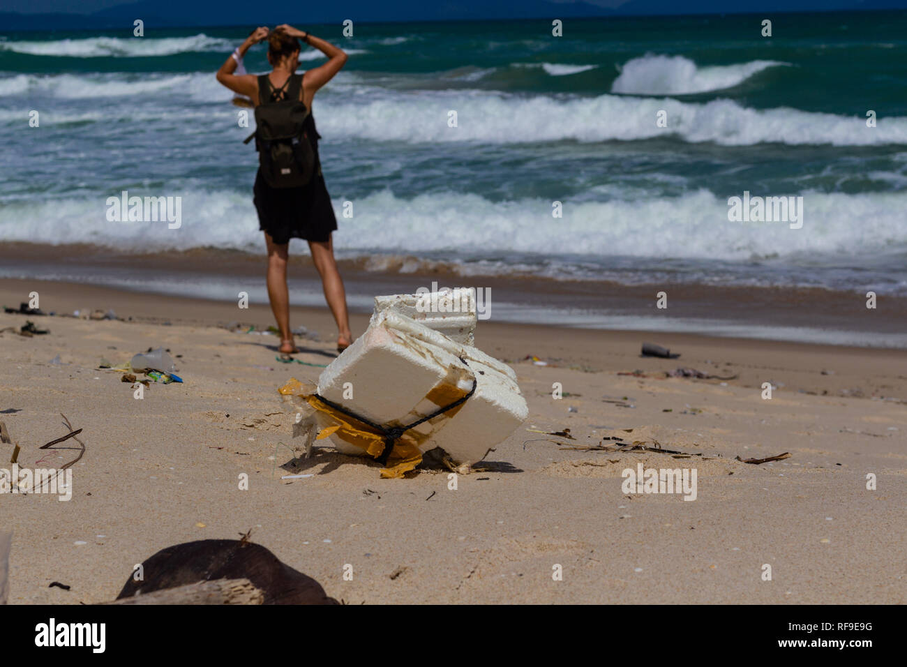 Strand Verschmutzung, Kunststoff und Abfälle von Ocean am Strand. Touristen auf den verschmutzten Strand. Stockfoto