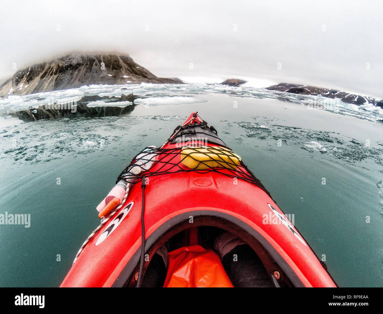 SVALBARD, Norwegen - Kajaktouristen erkunden das eisige Wasser und die unberührten Landschaften der Arktis rund um Svalbard. Diese einzigartige und abenteuerliche Form des Tourismus bietet ein Erlebnis aus nächster Nähe mit der arktischen Umgebung und zeigt die atemberaubende Schönheit und empfindliche Ökosysteme der Region. Stockfoto