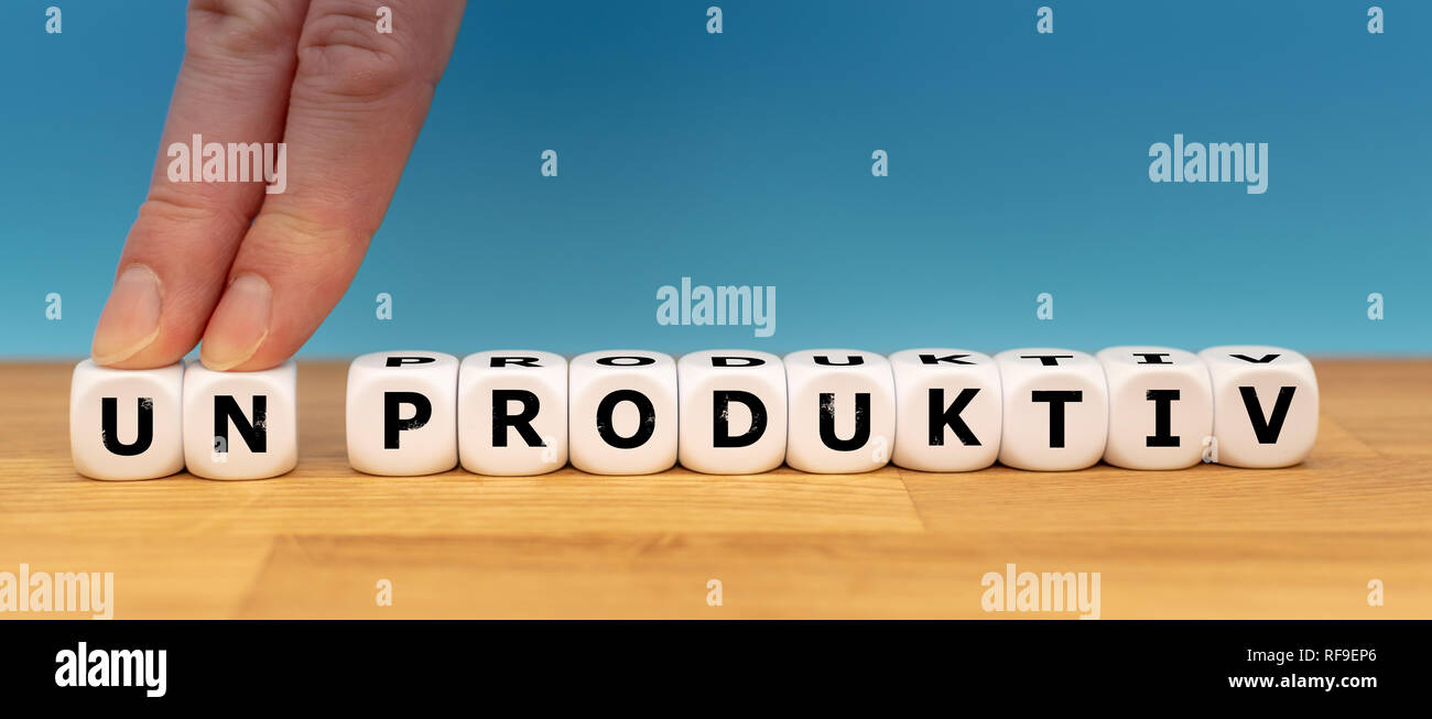 Würfel Form das deutsche Wort "UNPRODUKTIV" ("UNPRODUKTIV" im Englischen), während zwei Finger die Buchstaben "UN" entfernt, um das Wort 'PROD ändern Stockfoto
