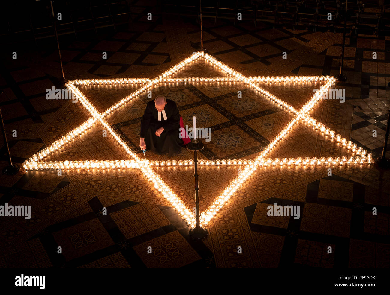 Canon Bundeskanzler Christopher Collingwood hilft sechs hundert Kerzen in der Form des David Stern Licht, im Speicher von mehr als 6 Millionen Juden durch die Nazis im Zweiten Weltkrieg ermordeten, an der York Minster in York. Stockfoto