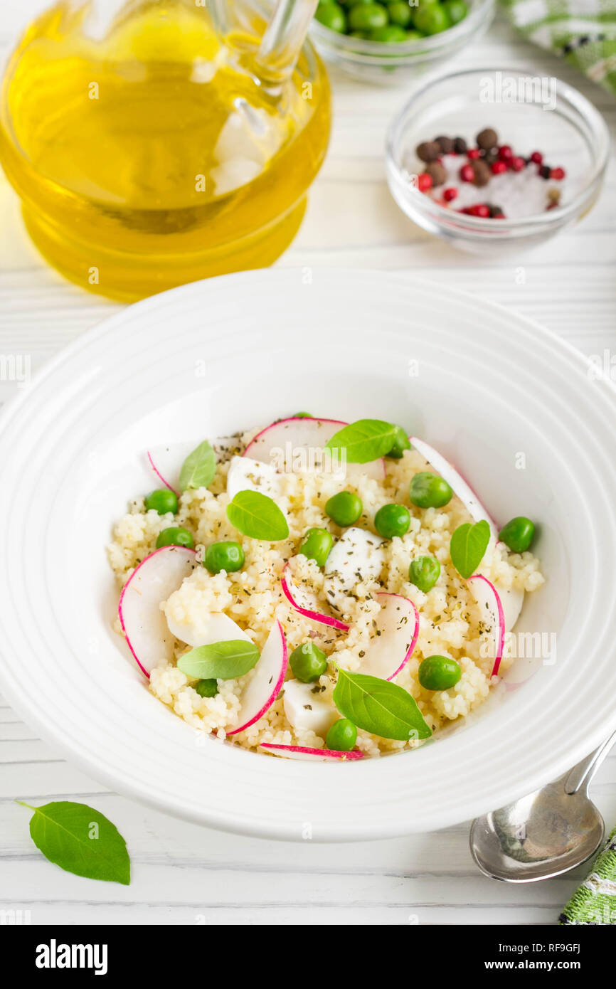 Salat mit Couscous, grüne Erbsen, Mozzarella und Rettich, Sommer gesundes Gericht Stockfoto