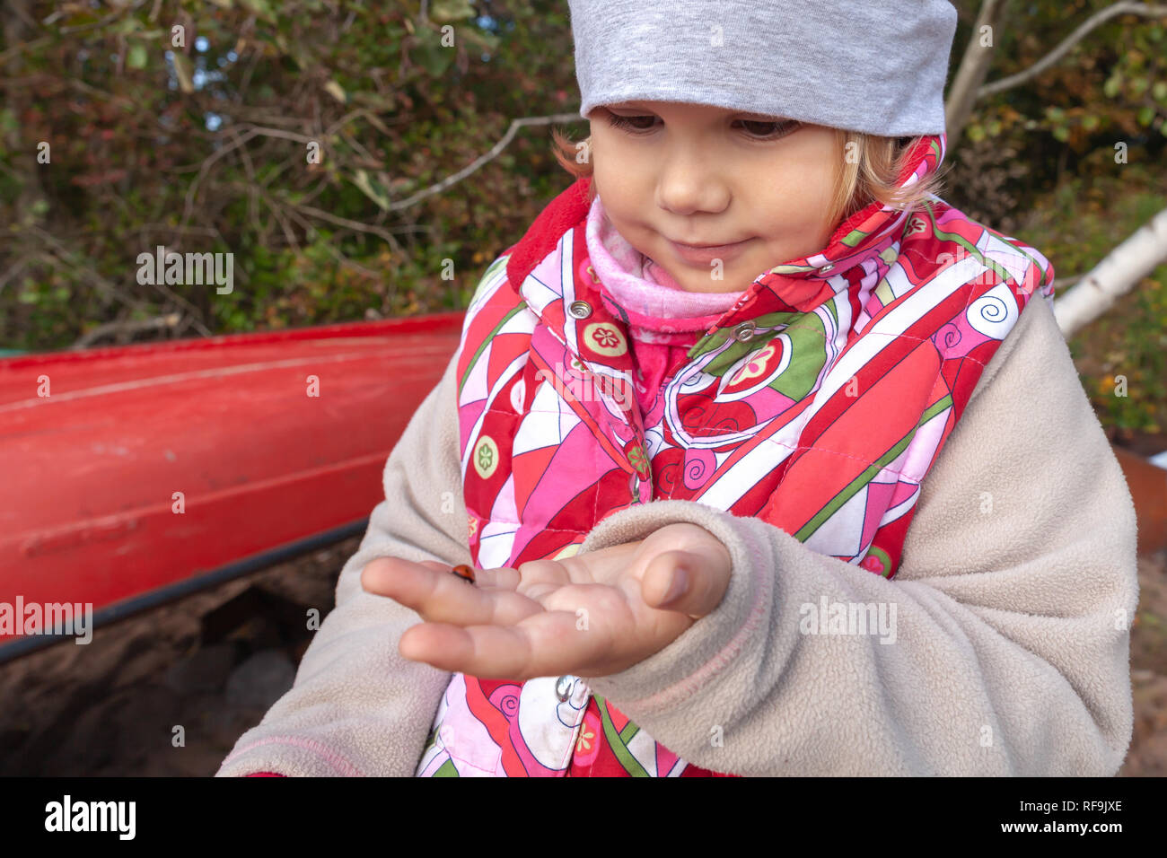 Wenig europäische Mädchen hält Marienkäfer in der Hand, outdoor Foto Stockfoto