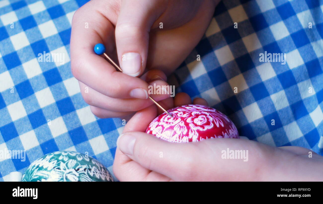 Mädchen Hände detail, die graviert Ostern Ornamente auf farbige Eier, mit Gravur Technik, typische Benutzerdefinierte in Osteuropa Stockfoto