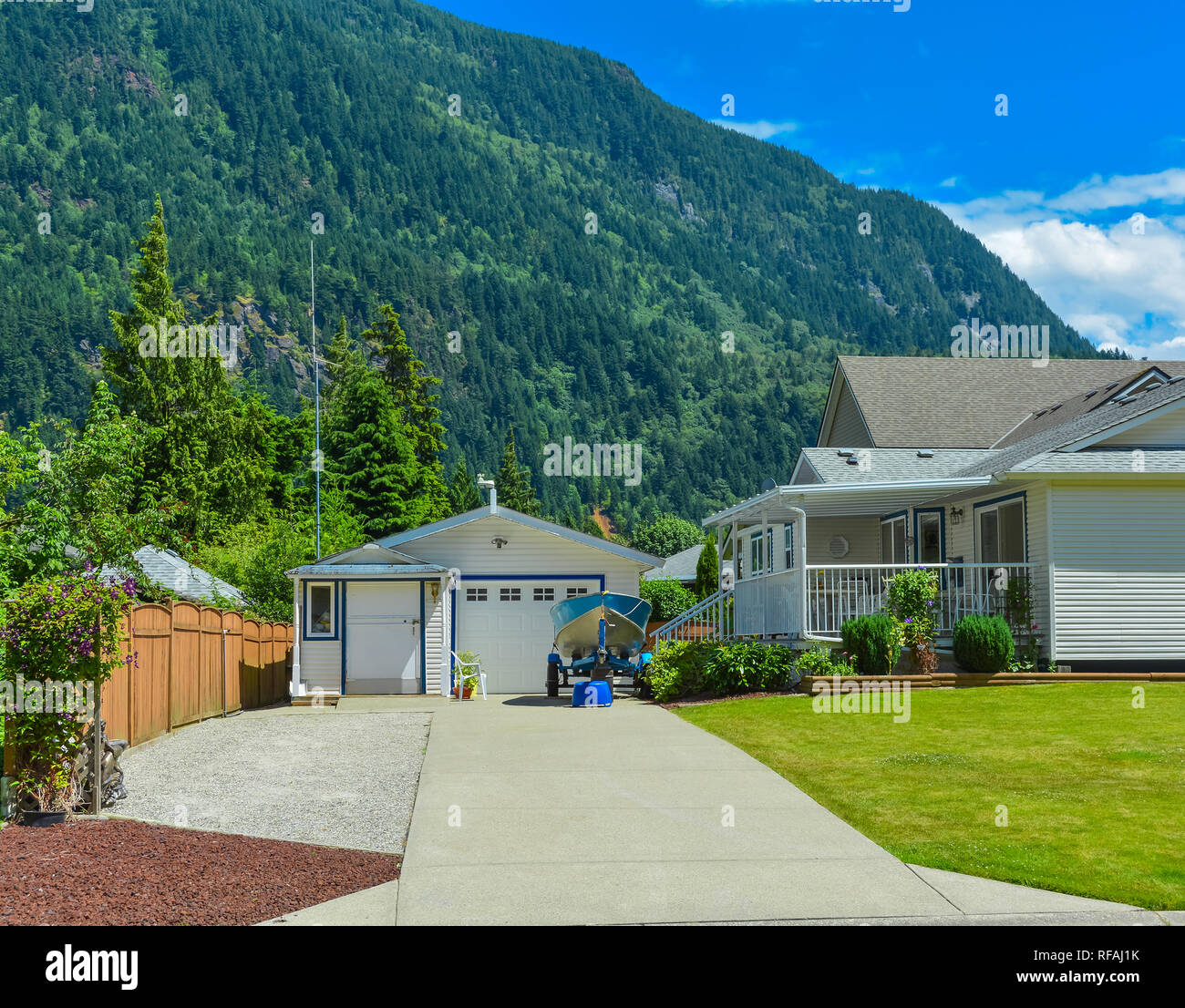 Wohnhaus mit Garage auf den Hinterhof und kleinen Boot in der Nähe geparkt durch Stockfoto