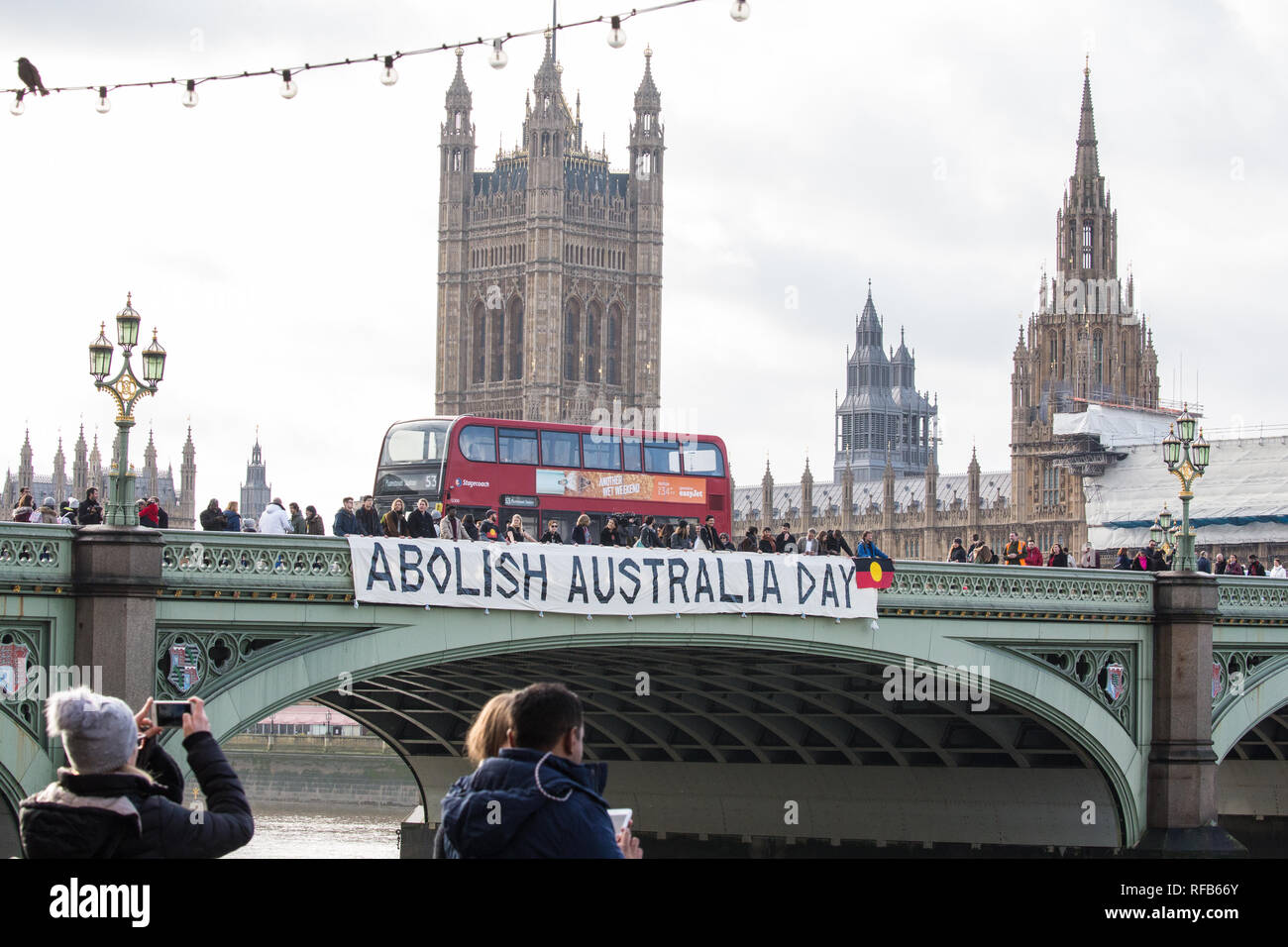 London, Großbritannien. 25. Januar, 2019. Aktivisten drop ein Banner von Westminster Bridge, im Blick auf die Häuser des Parlaments, für die Abschaffung von Australien Tag der Kundgebungen in jedem australischen Stadt morgen an. Die Veranstaltung wurde in Solidarität mit den Aborigines und Torres Strait Islander Wer Australien Tag, ein Tag feiert die Besiedlung von Australien, ein Tag der Trauer eher als ein Tag der Feier werden organisiert. Credit: Mark Kerrison/Alamy leben Nachrichten Stockfoto