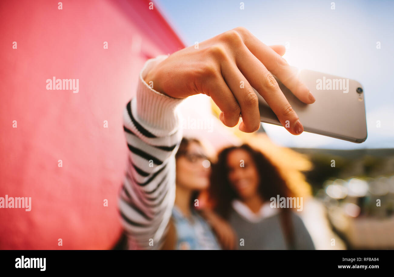 Mädchen Reisende, die sich ein selfie mit Handy. Verschwommenes Bild von Frauen, die im Freien und posieren für ein selfie. Stockfoto