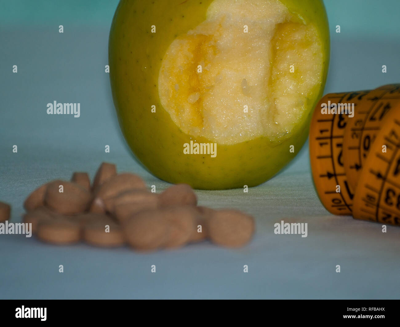 Eine gebissen Apple, ein Maßband und Pflanzenfasern Pillen auf einem Tisch Stockfoto