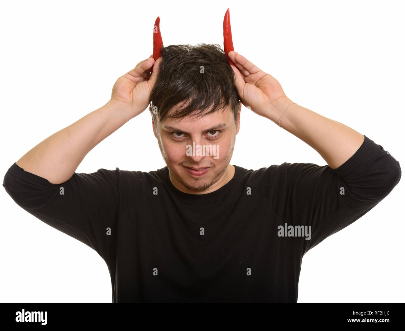 Studio shot Verrückter kaukasischen Mann mit rotem Paprika wie Hörner Stockfoto