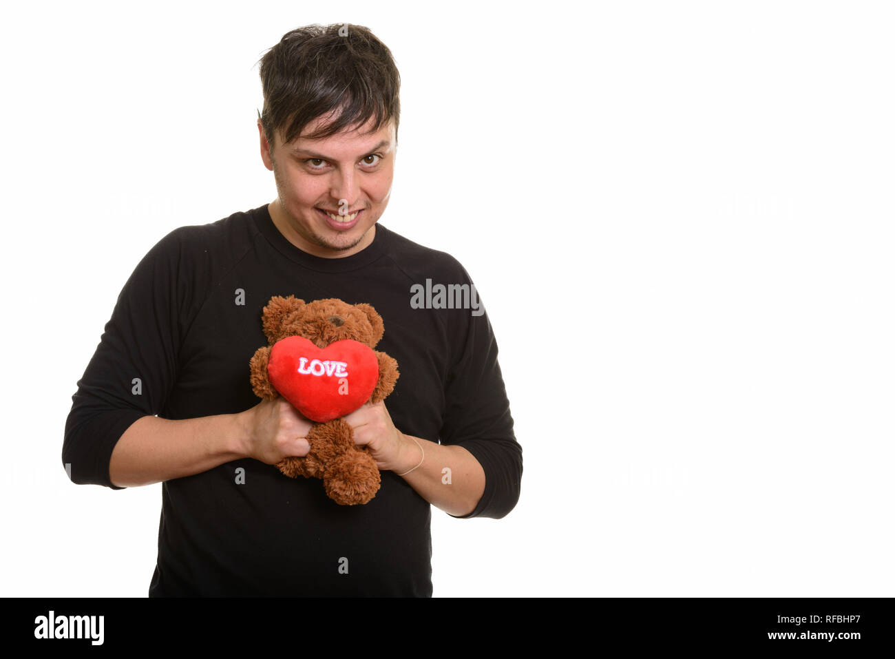Studio shot Verrückter kaukasischen Mann quetschen Teddybär mit Hea Stockfoto