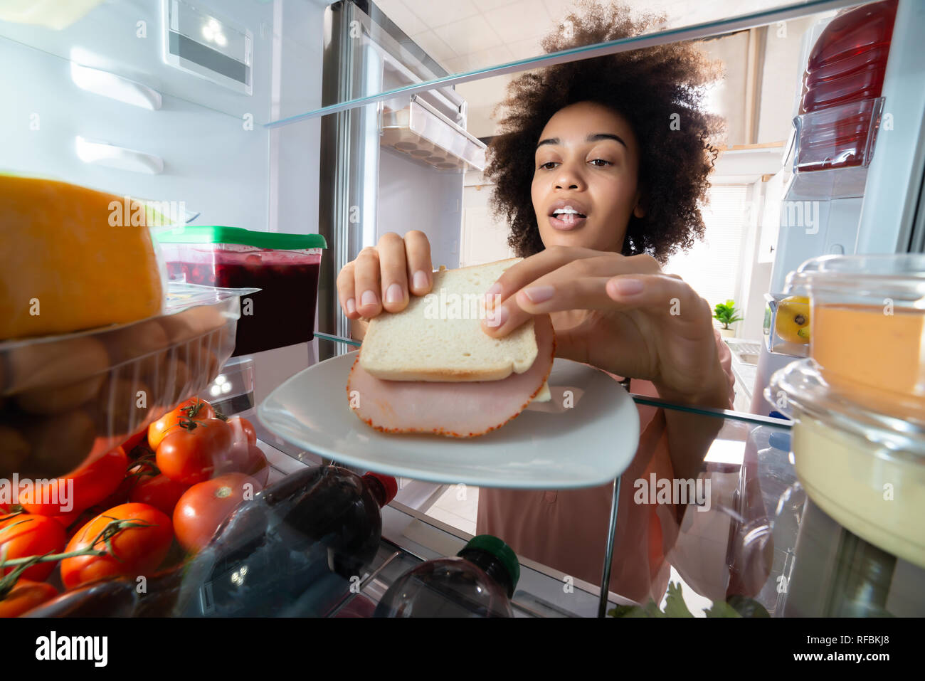Hunger Frau, Schinken Sandwich von der Platte Im Kühlschrank Stockfoto