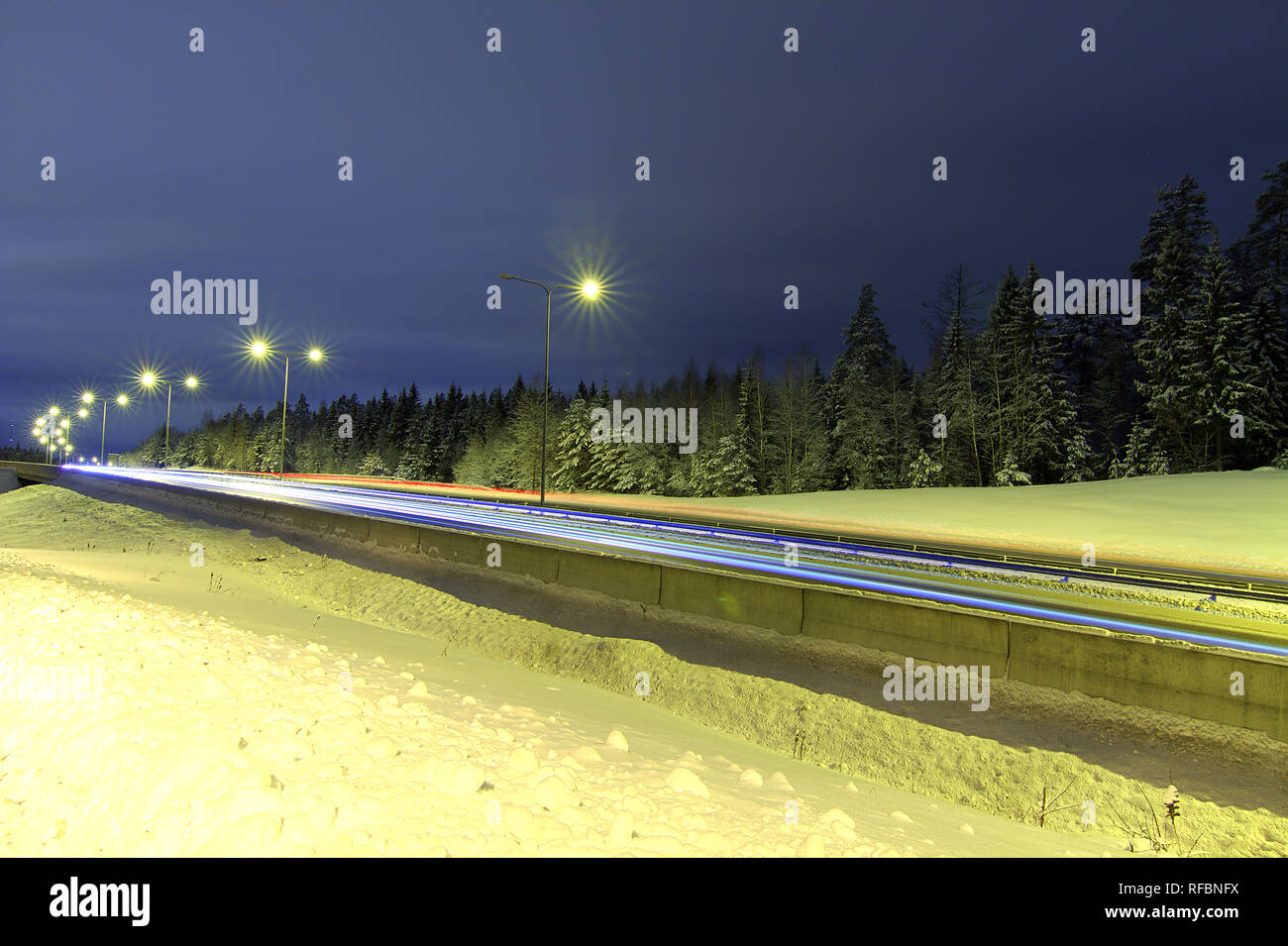Leichte Wanderwege der Autos auf verschneiten Autobahn Stockfoto