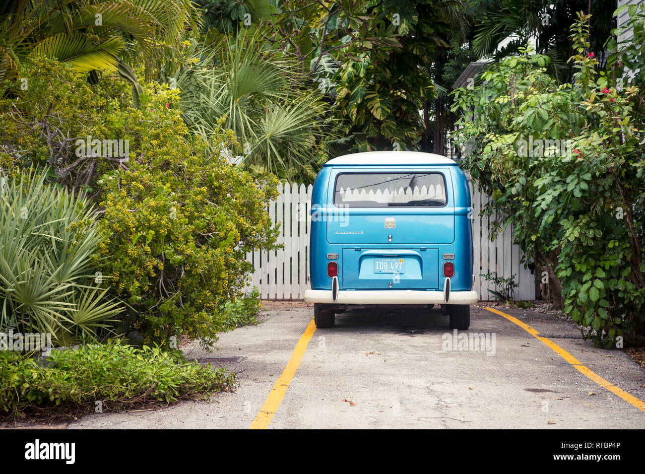 KEY WEST, Florida, USA - Januar 14, 2019: Üppiges Grün umgibt eine klassische Volkswagen van am Ende einer ruhigen Gasse geparkt. Stockfoto