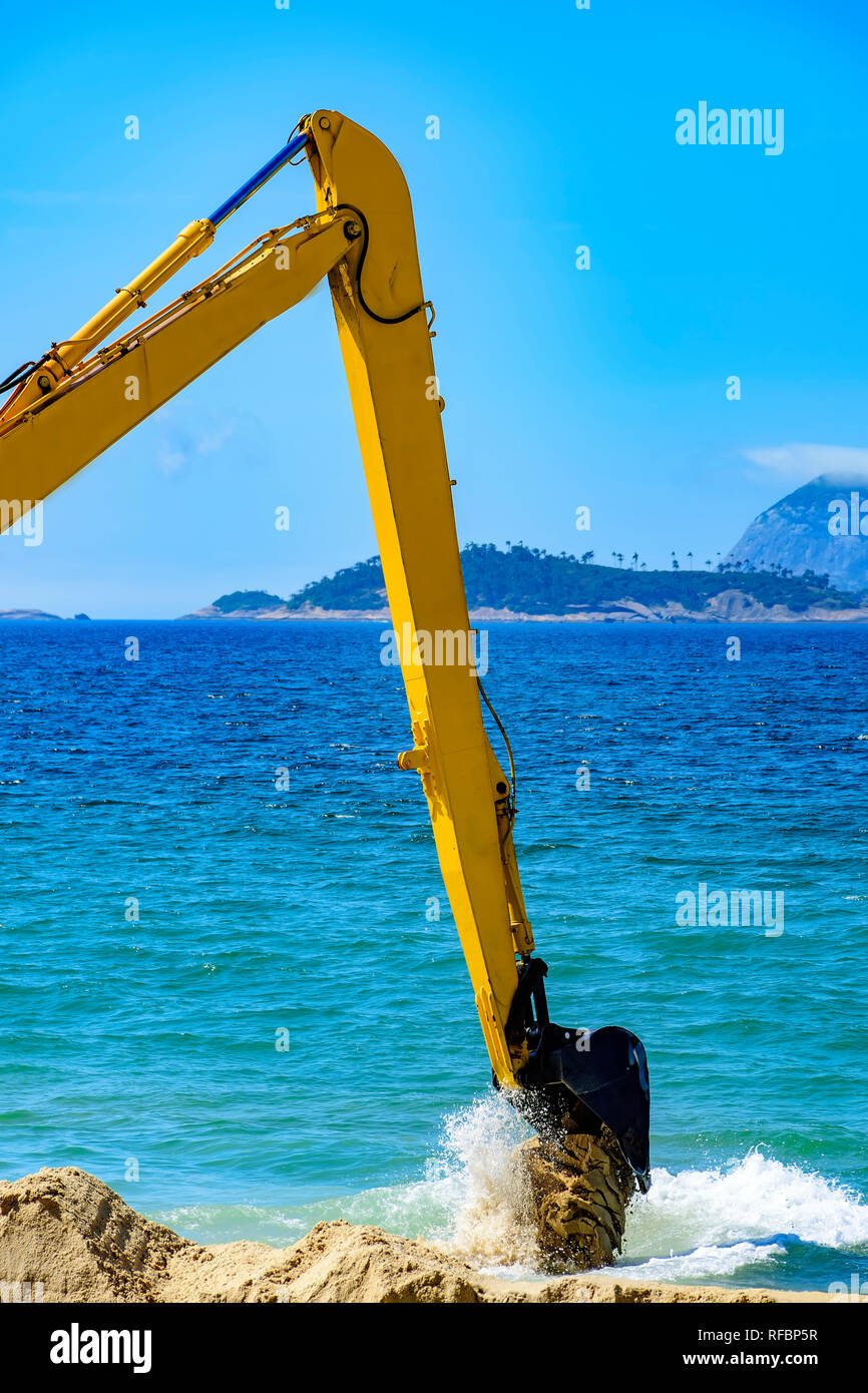 Tiefenlöffel entfernen Sand vom Strand und werfen in das Meer der Passage zu reinigen Stockfoto