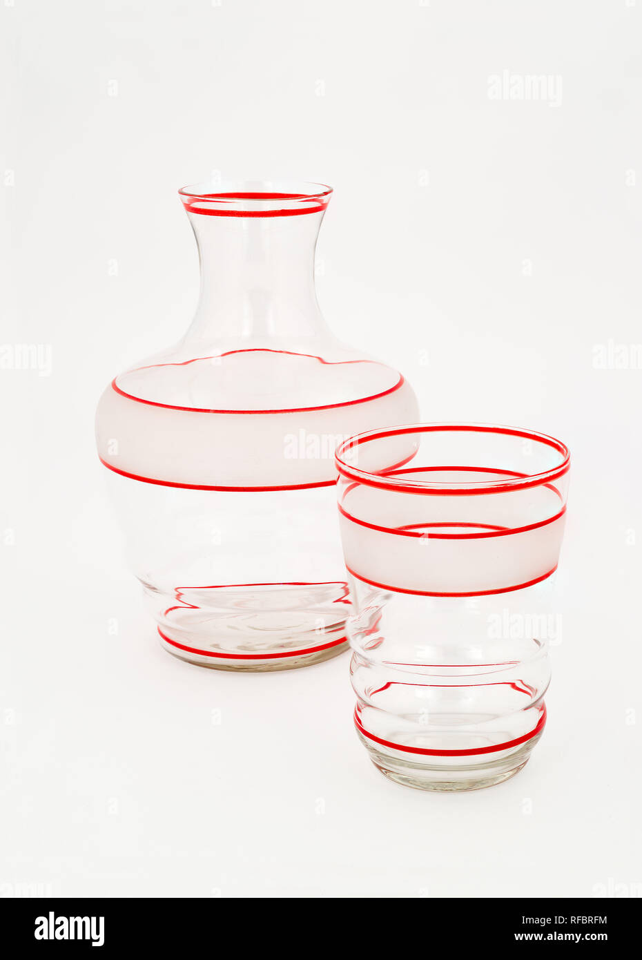 Der 1940er Jahrgang klar und geätztem Glas Kanne und Glas mit roten Streifen. Stockfoto