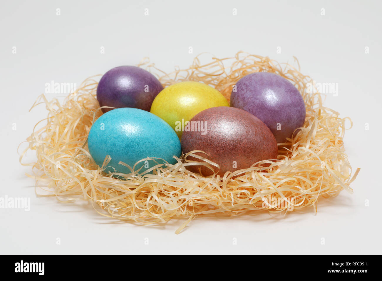 Bunte Ostereier im Nest auf weißem Hintergrund, Feder Bild. Ostern Konzept. Stockfoto