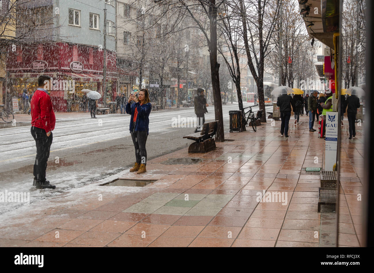 ESKİSEHİR, Türkei - Januar 15,2019: Schneefall in der Stadt. Die Menschen sind zu Fuß auf der Straße im Winter. Die Frau nehmen Sie Fotos ihrer Freundin unter Schnee und ma Stockfoto