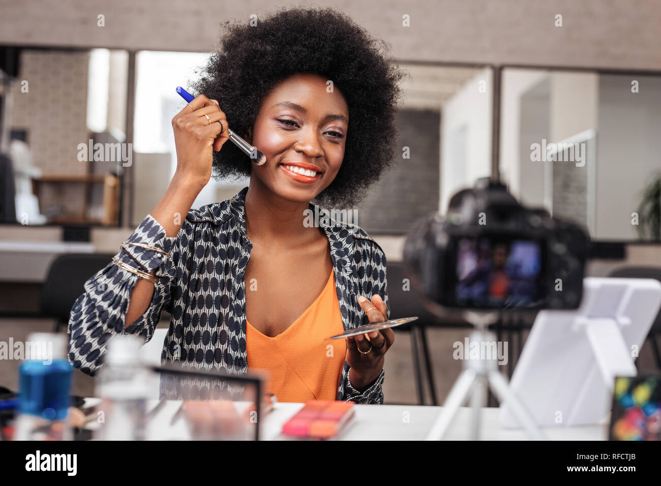 Schöne afrikanische amerikanische Frau mit lockigem Haar, Kosmetik test Stockfoto