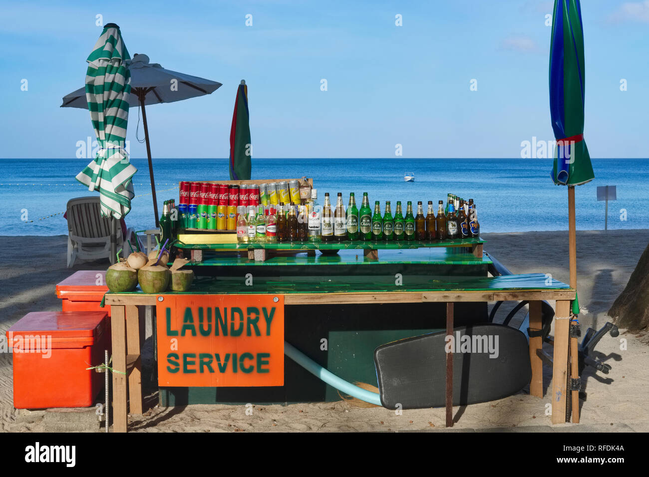 Flaschen von Singha und Chang Bier, kalte Getränke Dosen und eine Werbung für ein Wäscheservice bei einem Getränke am Bang Tao Beach, Phuket, Thailand Abschaltdruck Stockfoto