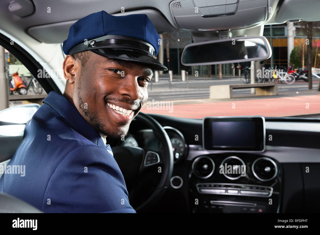 Portrait Of Happy afrikanische Mann Chauffeur im Auto sitzen Stockfoto
