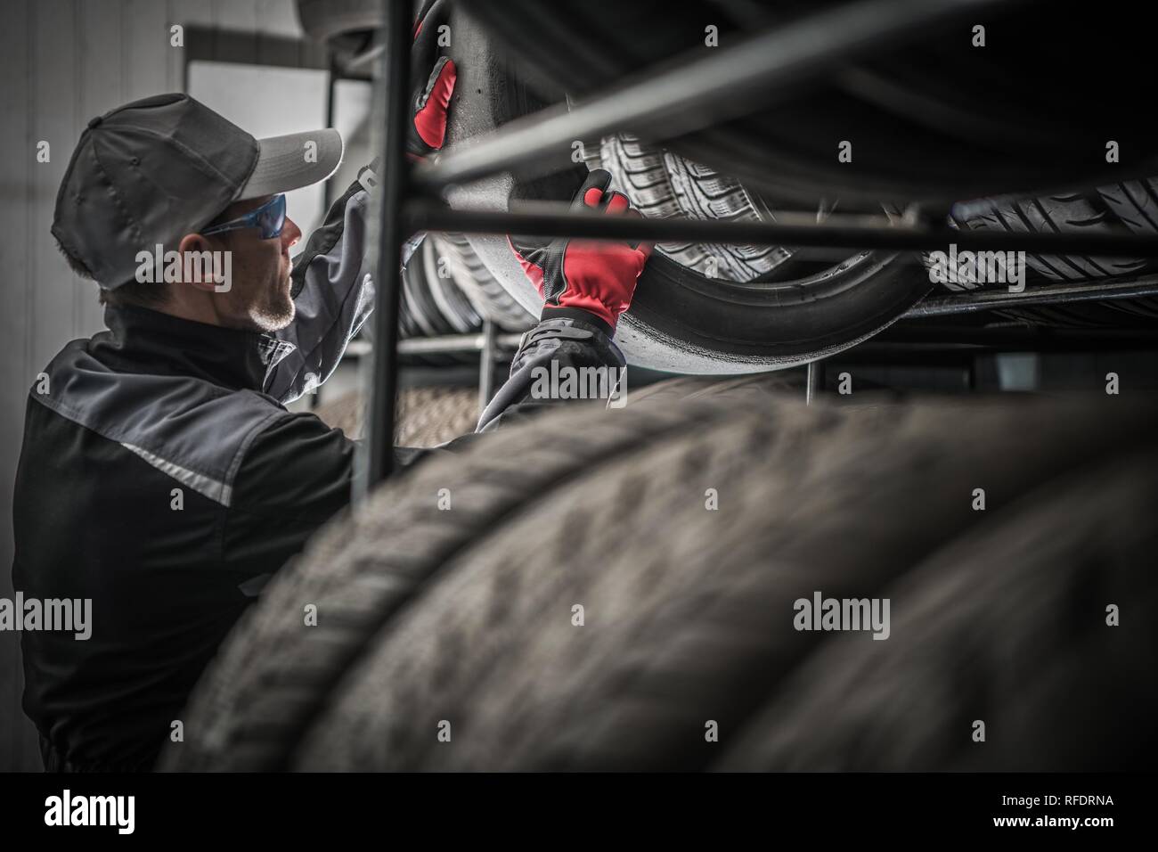 Reifen Store Arbeiter und neuen Reifen-Racks. Automotive Services Konzept. Stockfoto