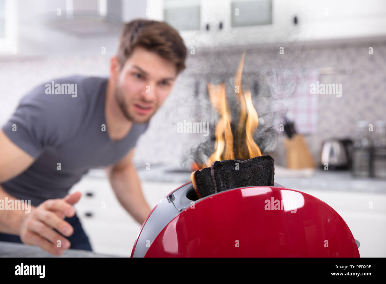 Portrait von Furchtsamen Mann auf Scheibe brennen Aus Toaster Stockfoto