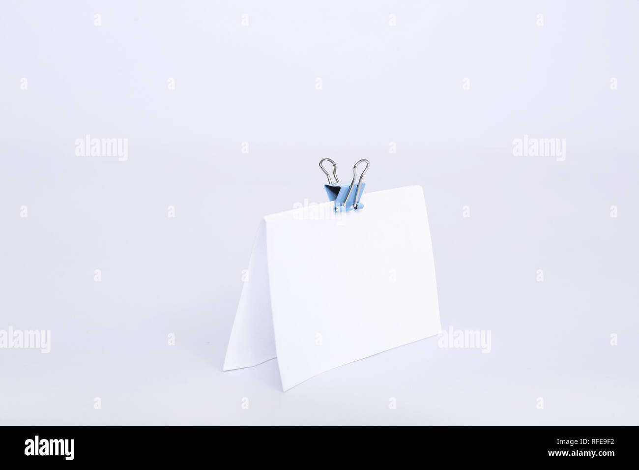 Portrait von leere weiße Karte mit Büroklammer befestigen. Auf den weißen Hintergrund isoliert. Stockfoto