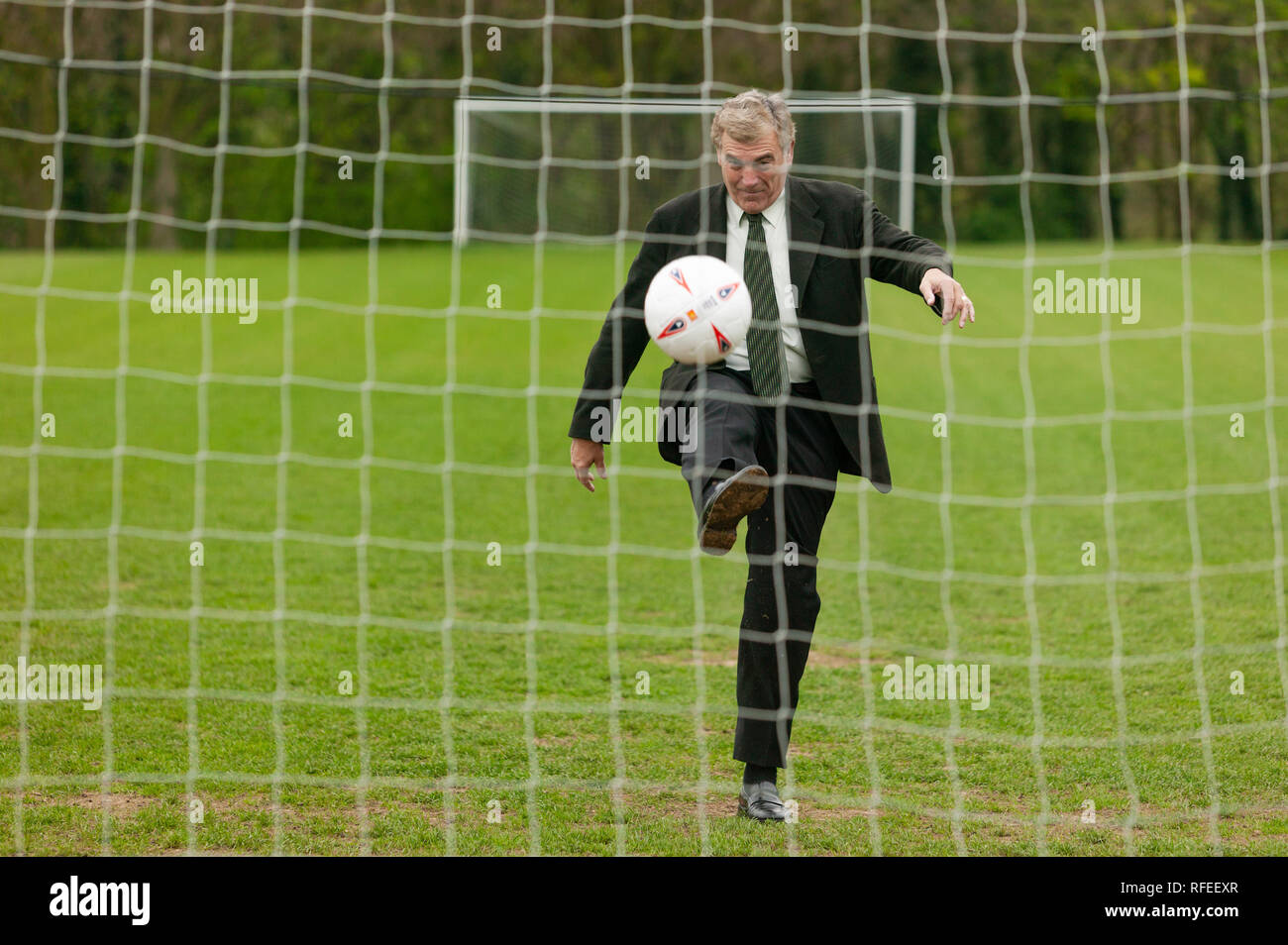 Ehemalige England footballer Trevor Brooking internationale West Ham MBE treten eines Fußball auf dem Weg zu einem net wie Elfmeter. Stockfoto