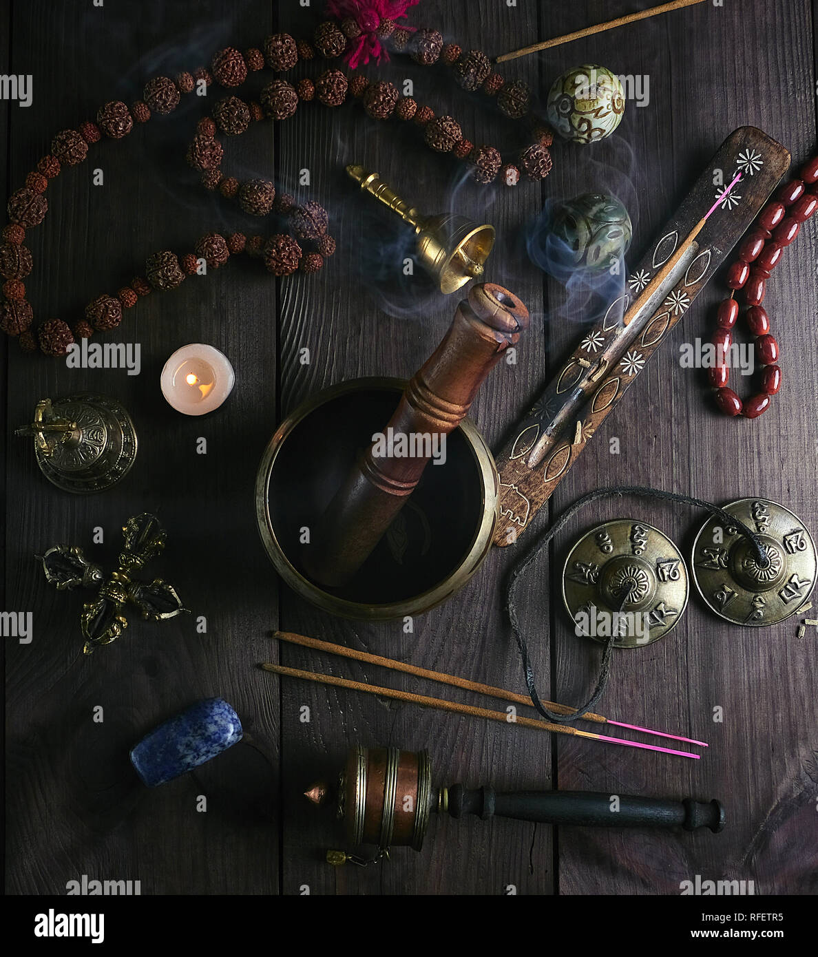Klangschale, Gebet, Perlen, Gebet, Trommel, Steinkugeln und anderen tibetischen religiösen Objekte für Meditation und alternative Medizin auf braunem Holz- ba Stockfoto