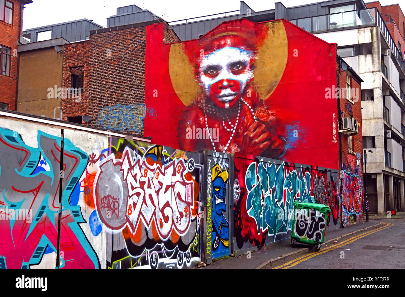Aboriginal face auf rotem Hintergrund von Graffiti, Speer St, Northern Quarter, Manchester, England, Großbritannien Stockfoto