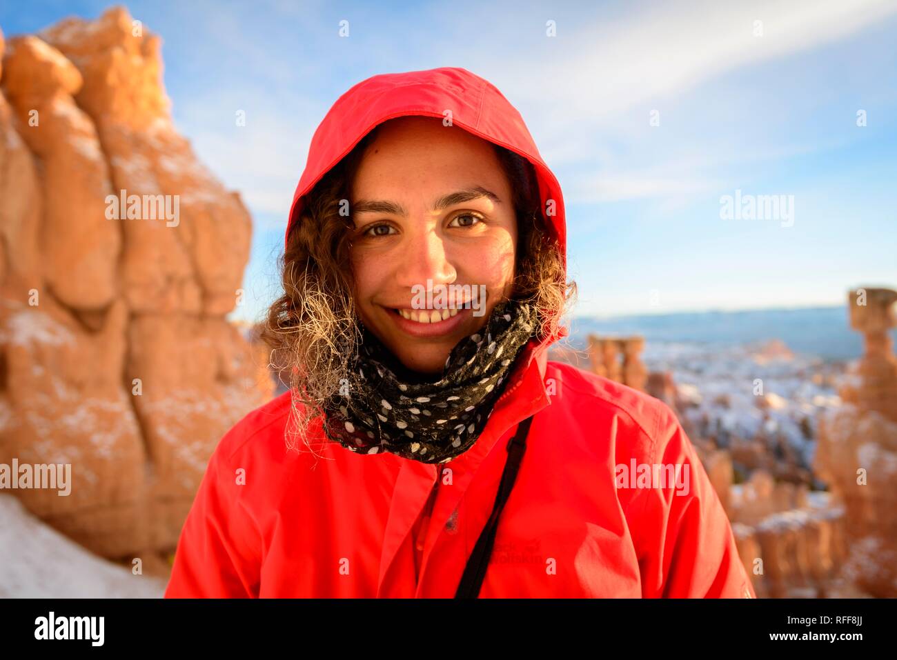 Portrait von eine hübsche junge Frau im Winter Kleidung vor Felsnadeln, Winter, Rim Trail, Bryce Canyon National Park, Utah Stockfoto