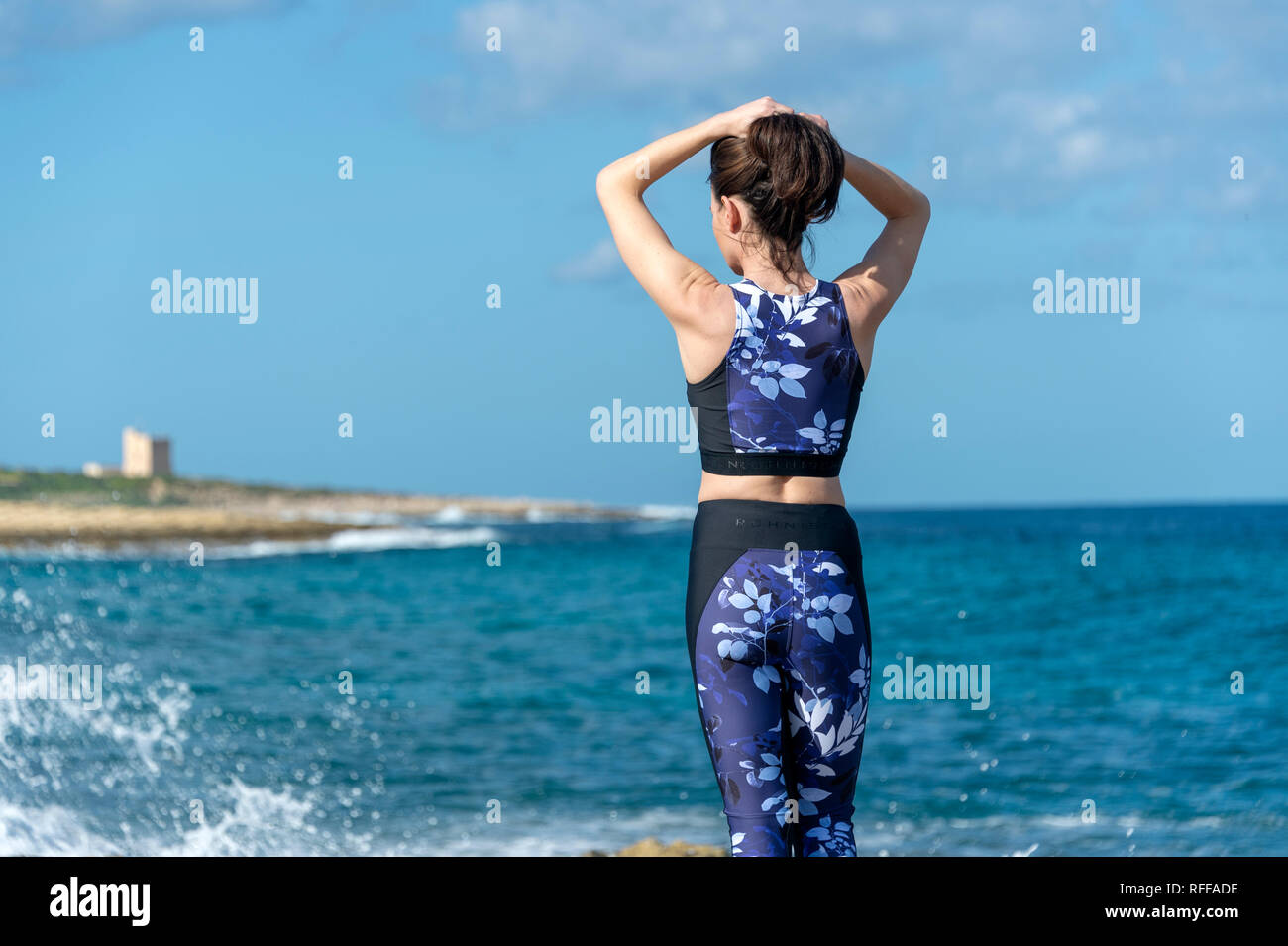 Sport Frau binden ihr Haar, Vorbereitung und Übung am Meer in der Sonne Stockfoto
