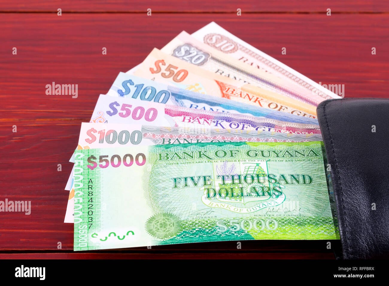 Guyanese Geld in der schwarzen Mappe Stockfoto