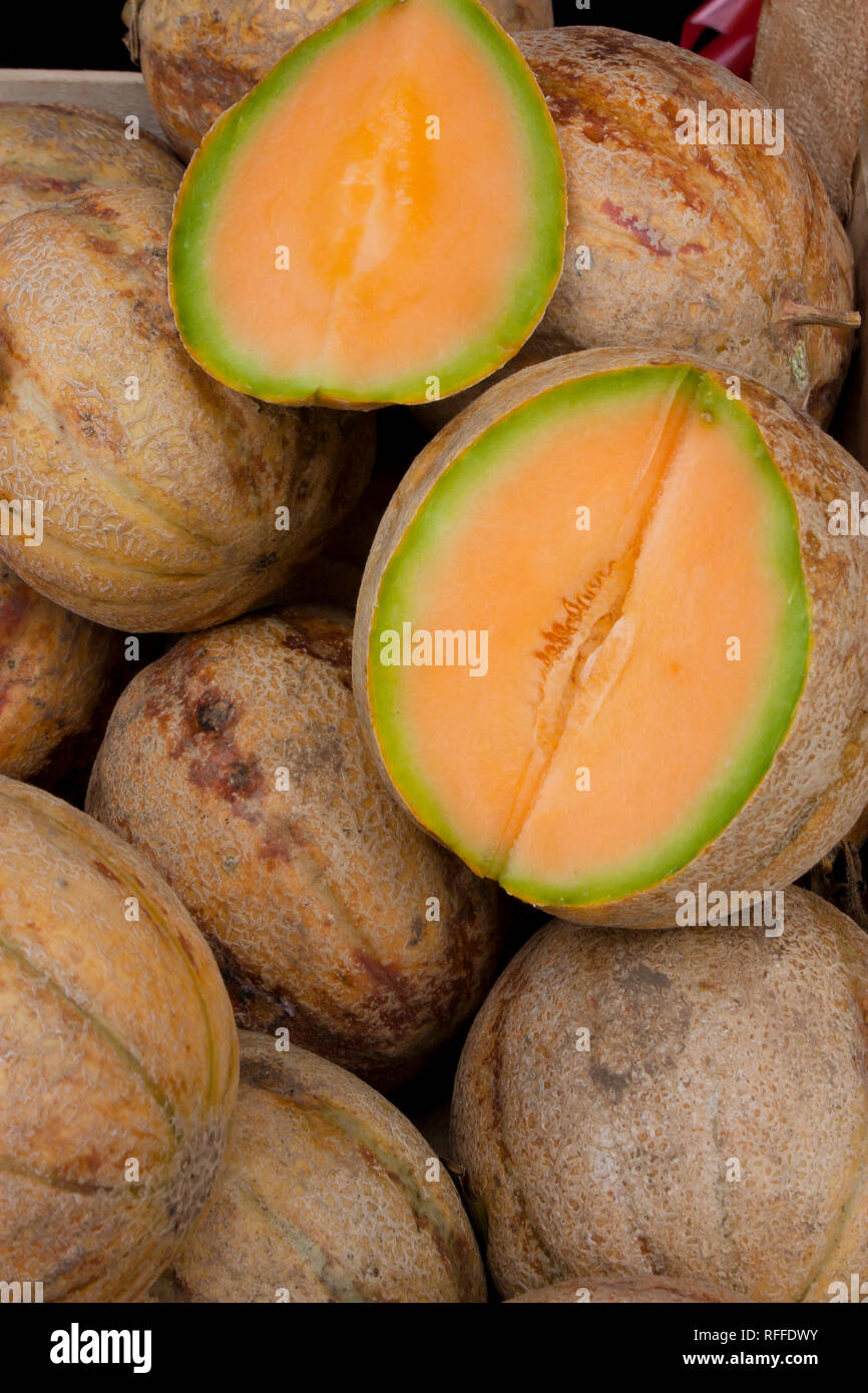 Bündel von organischen Melonen, und ein in der Hälfte zeigt seine orange Fleisch, auf Verkauf am Wochenmarkt in Serbien angezeigt, Detail Stockfoto