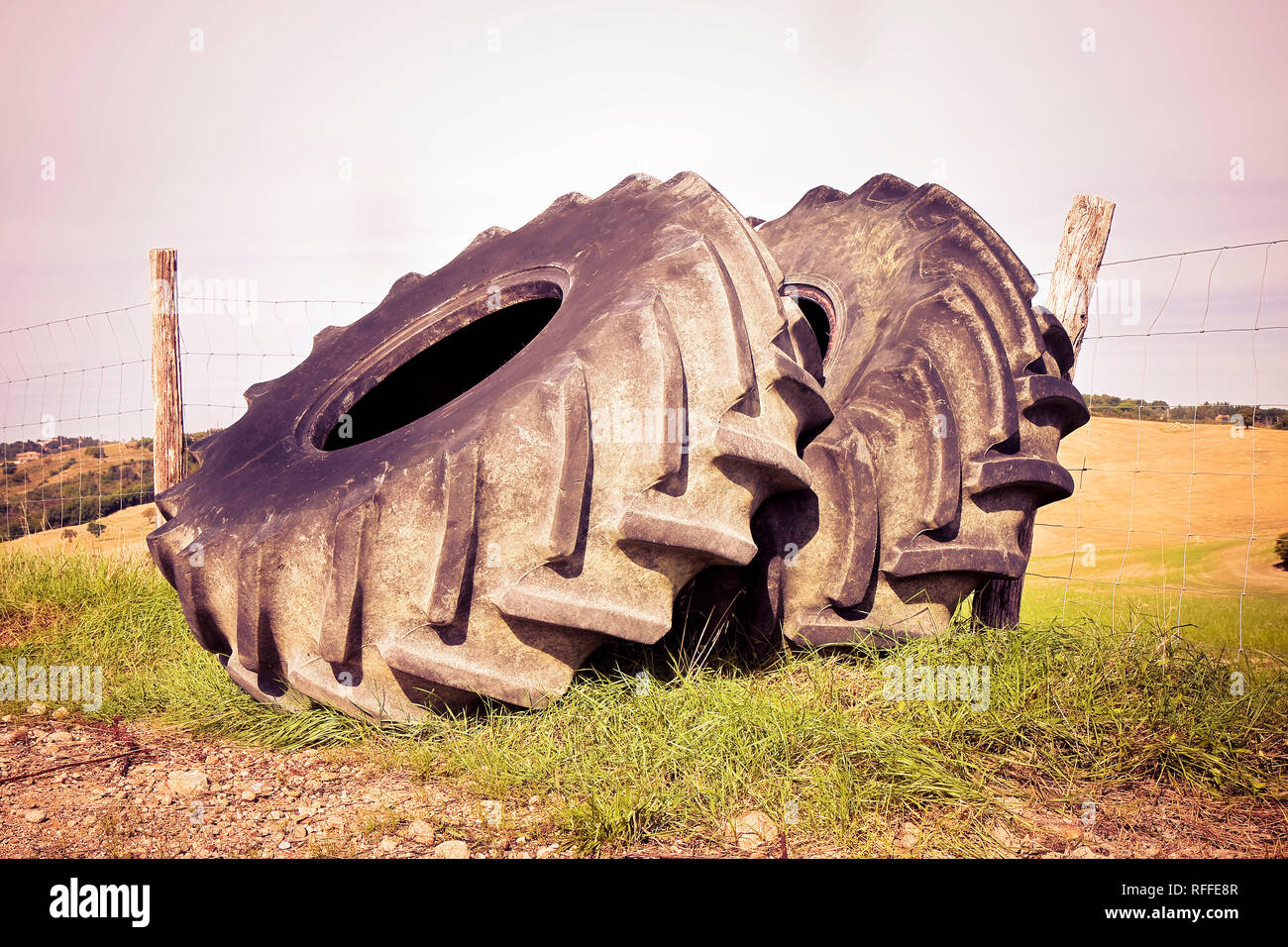 Alte abgebaut werden paar Reifen eines großen Traktor in einem Land, Road-getonten Bild Stockfoto