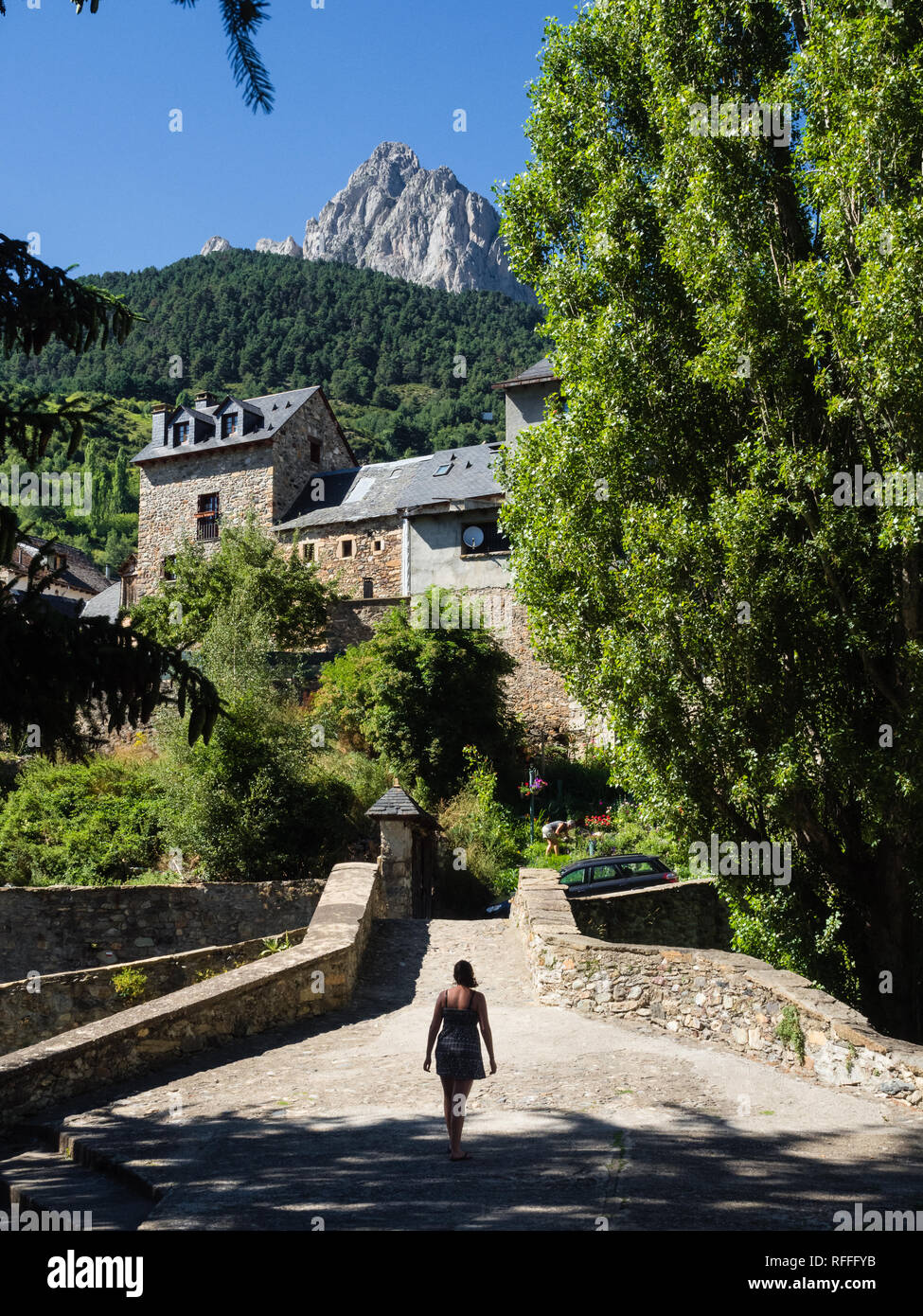 Mädchen zu Fuß durch das Dorf von Sallent de Gállego in den spanischen Pyrenäen, Aragon, Spanien Stockfoto